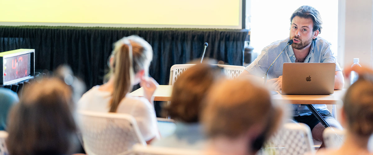Un tuteur qui enseigne un classe pendant que les étudiants écoutent