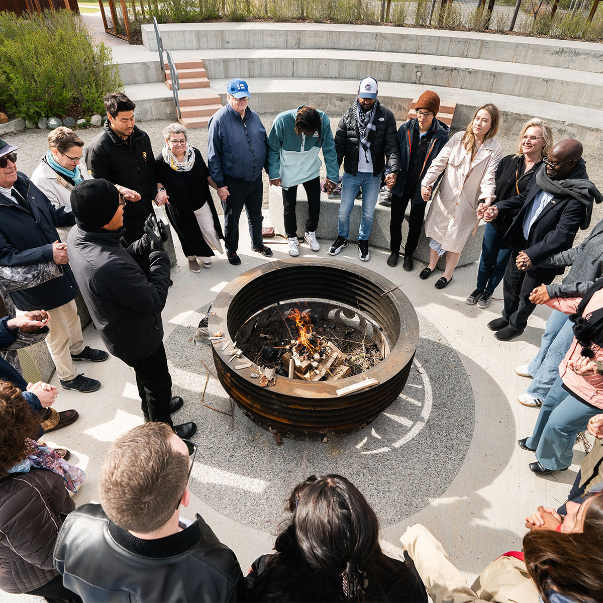 Des personnes autour d'un feu qui écouter quelqu'un parler